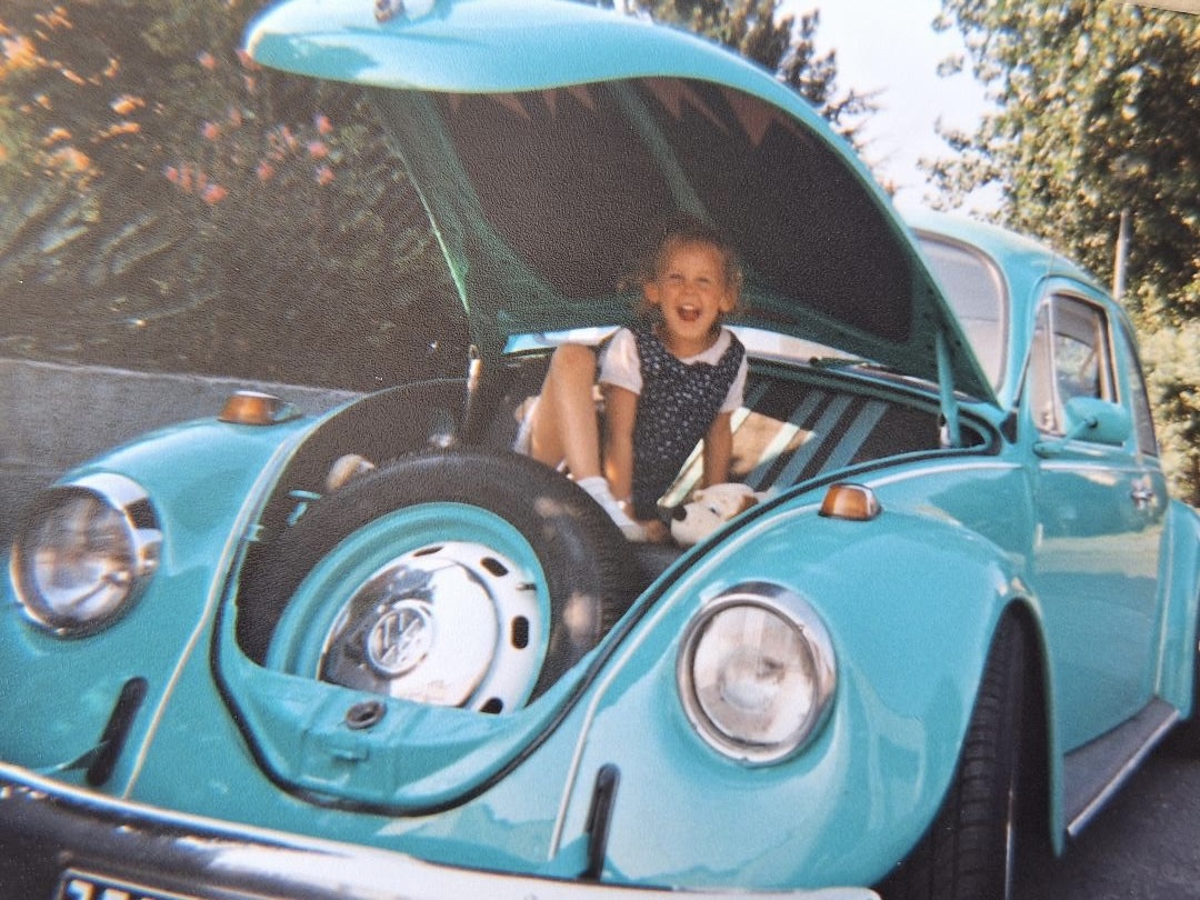 photo créatrice enfant qui pose dans une voiture vintage